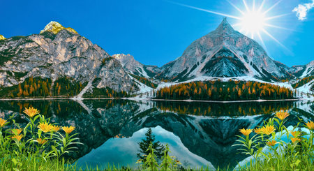 Mountain lake with alpine meadow and snow-capped peaksの写真素材