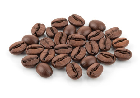 A pile of dark roasted coffee beans is presented isolated on a clean white background.の素材