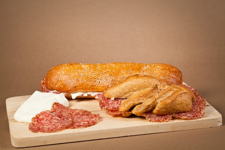 Two sandwiches wit italian sliced salami and fresh cheese over a wooden boardの写真素材