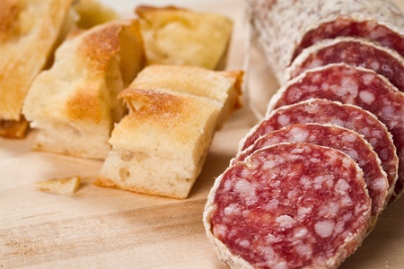 sliced salami with focaccia pizza over a wooden chunkboardの写真素材