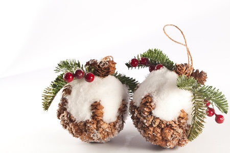 Pine cone christmas balls whit leaves, snow and berry on top. Isolated studio shot with white background and copy spaceの写真素材