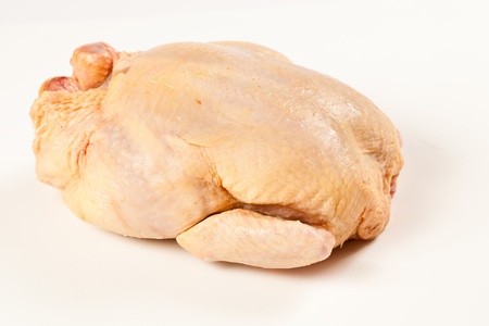Fresh uncooked chicken. Isolated studio shot over white boardの写真素材