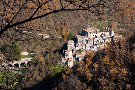 aerial view of rural village of Percile in Italy. Framed with tree branches in autumnal colorsの写真素材