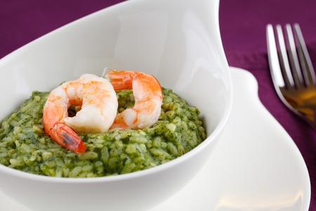 Delicious rice with spinach, greens and shrimps. Served in a modern dishware over a purple table settingの写真素材