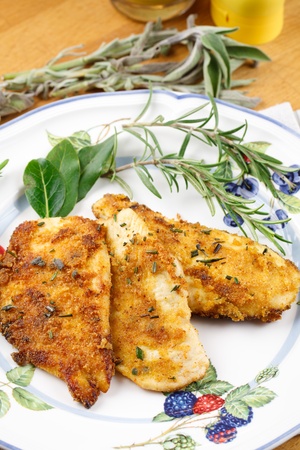 Delicious slices of chicken breast, marinated in herbs and decorated with herbs leafs and sprigs. Served in a country stile setupの写真素材
