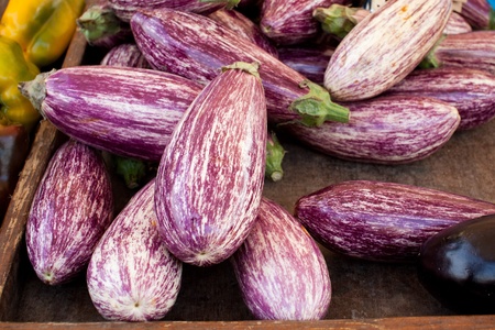 Box of fresh eggplants at market boothの写真素材