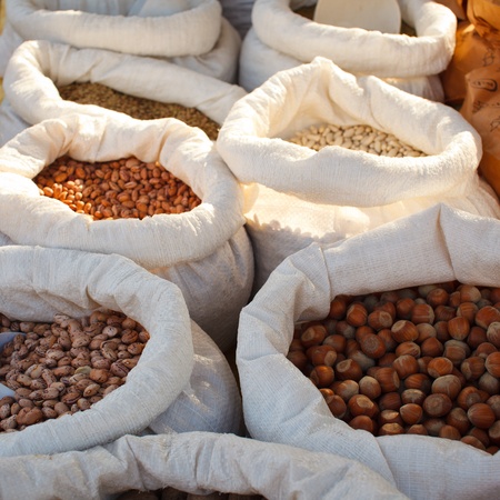 Jute bags full of beans and nuts in a market stallの写真素材