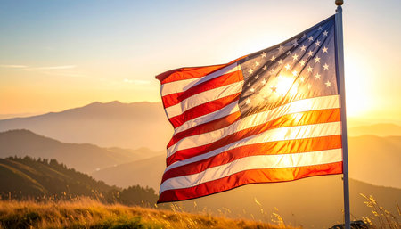 American flag on the top of the mountain in the rays of the rising sunの素材