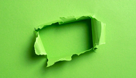 A bright green paper has a jagged hole torn in it, revealing a lighter green surface underneath.の素材
