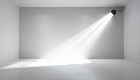 Minimalist empty room with a single spotlight casting a bright beam on the wall and floor.の素材