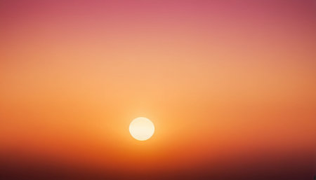 A bright white sun is centered in a sky with a smooth gradient of pink, orange, and yellow colors.の素材