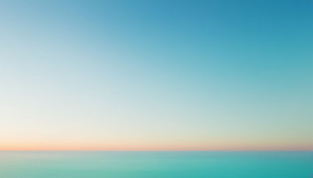 A clear blue sky meets a vibrant turquoise ocean at the horizon, creating a serene and tranquil natural scene.の素材
