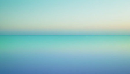 A serene horizon line divides a soft, faintly colored sky from a tranquil ocean with a smooth gradient of blue and...の素材