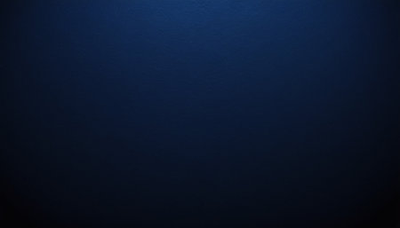 A deep navy blue textured background is lit softly from the left, with the light fading into darkness.の素材