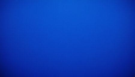 A vibrant cobalt blue gradient fills the frame with subtle texture and soft, even lighting.の素材