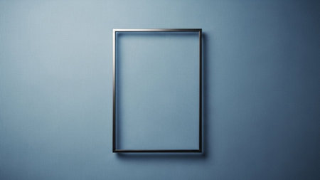 Empty showing minimalist silver metal frame centered on a textured pale blue wall with subtle lighting and shadow...の素材