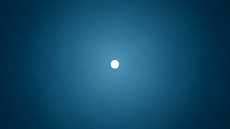 A solitary white circle emits a soft glow against a deep blue gradient, creating a minimalist and atmospheric...の素材
