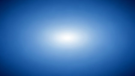 A bright white light radiates from the center of a deep blue gradient background with a soft glow.の素材