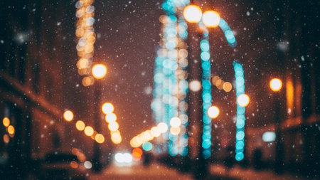 Bokeh showing nighttime city street scene with falling snow and blurry bokeh lights of streetlamps and buildings....の素材
