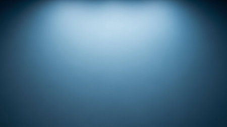 A smooth, soft blue gradient fills the frame with a brighter, diffused light emanating from the center, creating a...の素材