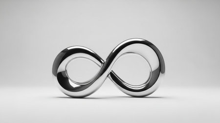 A highly polished silver infinity symbol sculpture is centered on a light gray studio background,...