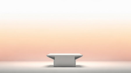 A clean white rectangular pedestal sits on a white surface against a soft peach gradient background.の写真素材