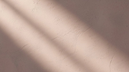 With showing textured pink wall with soft diagonal sunlight shadows creating a warm and serene atmosphere.の写真素材