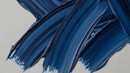 showcases thick, textured impasto brushstrokes of a deep, rich blue paint applied to a white canvas. The paint is applied with a heavy hand, creating visible ridges and valleys that catch the light, highlighting the tactile of the medium. The contrast between the dark blue and the bright white background is striking, emphasizing the bold and expressive nature of the close-up perspective reveals the intricate details of the paint application, offering a glimpse into the creative process.の素材