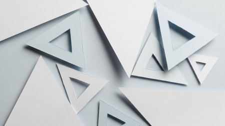 a collection of overlapping geometric triangles made of paper. The shapes are rendered in shades of white and light grey, creating a clean and minimalist aesthetic. Soft shadows are cast between the layers, adding depth and dimension to the composition. The overall impression is one of modern and abstract various and applications.の素材