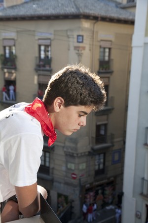 Teenager watching the bulls run, San Fermin, Pamplona, Navarra, Spainの写真素材
