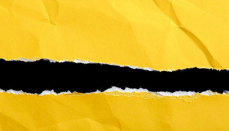 Hole ripped in yellow paper with black space for your message.の素材
