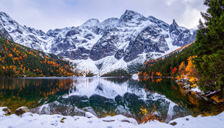 Mountain lake with snow and reflection in the autumn season. The concept of active and photo tourismの素材