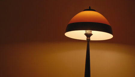 Lamp on the wall in a room with orange light and shadowの素材