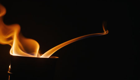 Flames of a burning candle on a black background close-upの素材