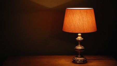 Lamp on a wooden table in a dark room. Dark background.の素材