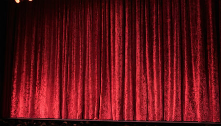 Red stage curtain background. Theater stage with red curtains and spotlight.の素材