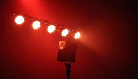 Spotlight on the stage with red light in the dark room.の素材