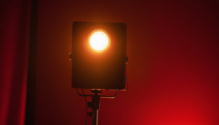 Studio light on red background. Studio lighting equipment on a red background.の素材