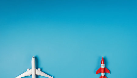 Miniature toy airplane on blue background with copy space. Travel and vacation conceptの素材