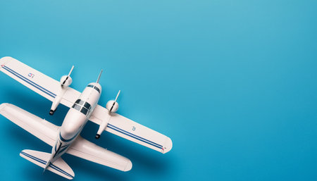 Miniature airplane on blue background. Top view. Copy space.の素材