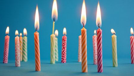 Birthday candles on blue background with shallow depth of field and copy spaceの素材