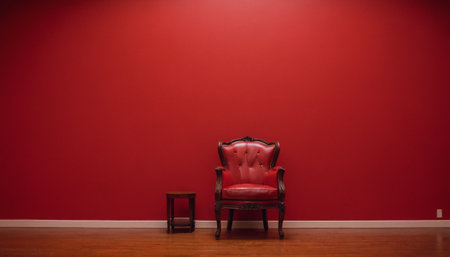 Red chair in the interior of an empty room with a red wallの素材
