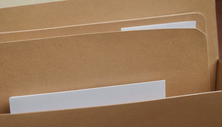 Close-up view of a stack of brown file folders with paper sheets.の素材