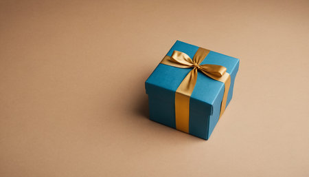 Blue gift box with gold ribbon on brown background, copy space.の素材