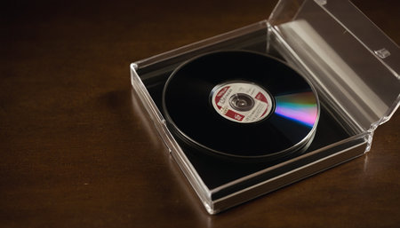 Compact disc in a box on a wooden table close-upの素材