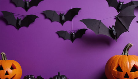 Halloween pumpkins and bats on purple background. Space for textの素材