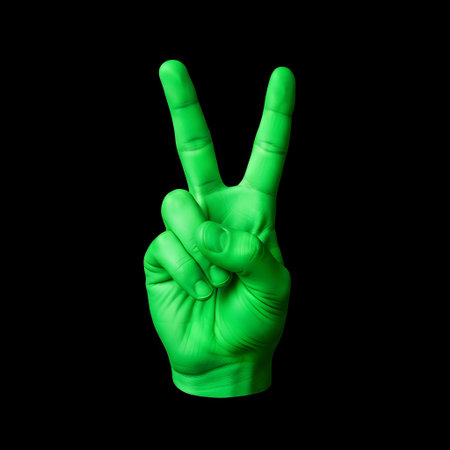 A bright green hand is shown against a stark black background, forming a clear V-shape with its index and middle fingers extended.の素材