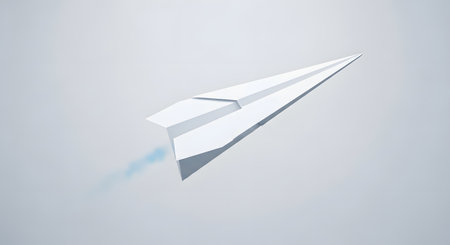 A minimalist image of a white paper airplane casting a subtle shadow on a plain, light gray surface. The plane is angled upwards.の素材