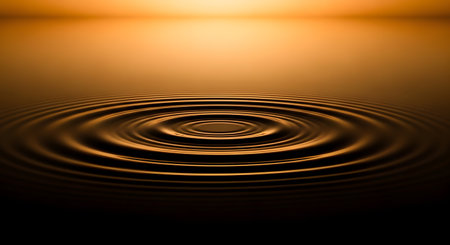 Concentric ripples spread across a dark, reflective water surface, illuminated by a warm, golden light from above.の素材