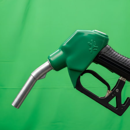 A close-up shot of a green fuel dispensing nozzle with a silver spout against a vibrant green background.の素材